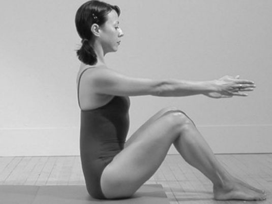 Sit tall, in your starting position, with your arms extended in front of you and your shoulders relaxed and dropped.