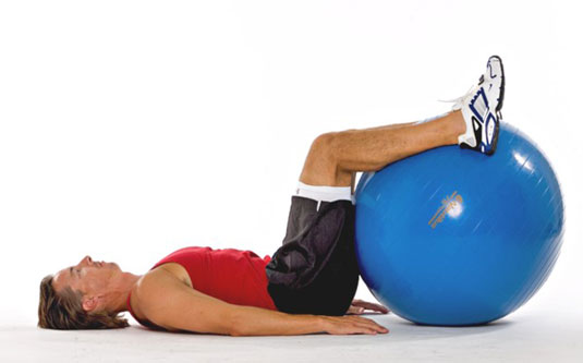 Lying on the floor, rest your lower legs on the ball.