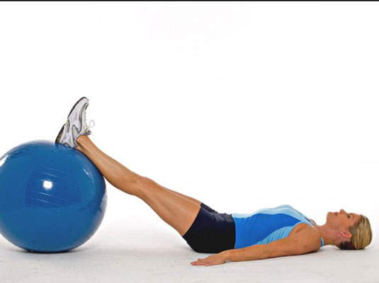 Lie on the floor with your feet placed on top of the ball.