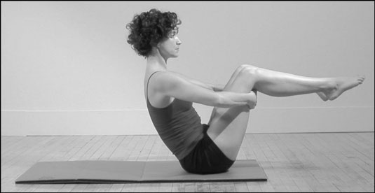 Woman does the Balance Point position in Pilates.