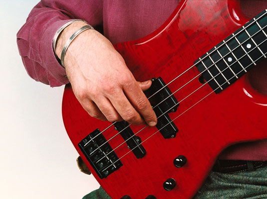 Let your hand approach the instrument until your thumb settles onto the thumb rest or the pickup.