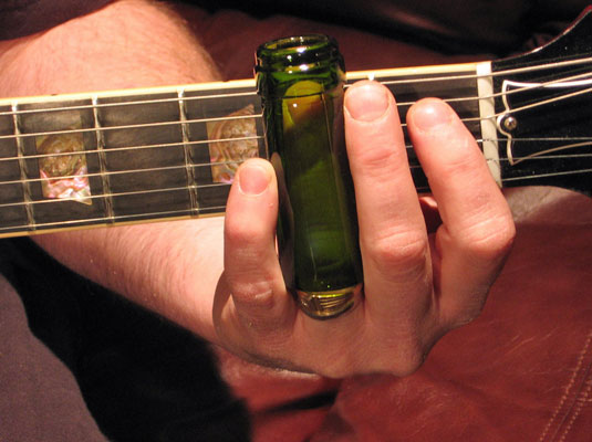 When playing the slide guitar, the musician wears a slide tube on the