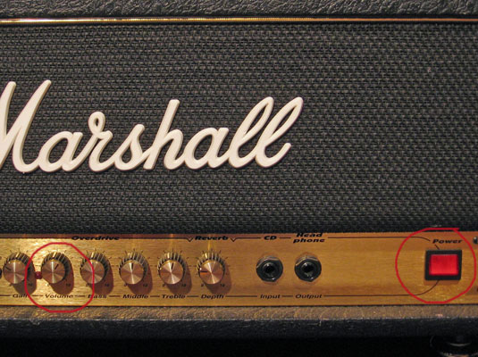 Find the volume knob(s) and turn them all the way down — usually fully counterclockwise.