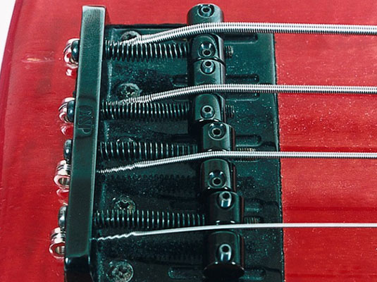 While increasing the tension at the tuning head with your left hand, use your right to make sure that the other end of the string stays in place.