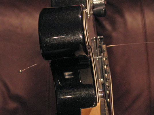 <b>Anchor the string at the bridge by passing the string through the hole (from the back or bottom of the guitar) until the ball stops the movement.</b>