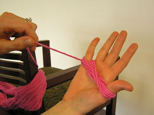 Wrap the yarn in a figure eight around the thumb and little finger of your hand several times to make a butterfly shape.