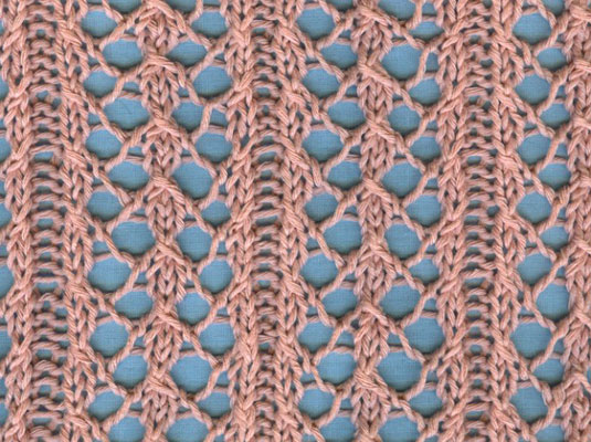 The blue background shows off the pattern in climbing vine knit lace.