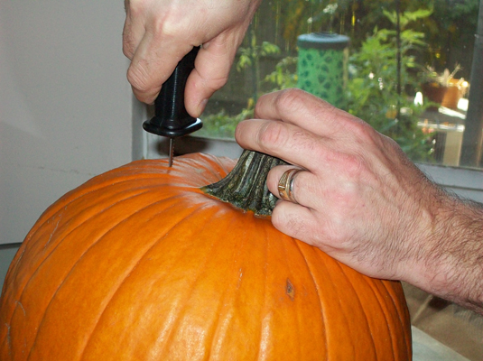 Cut a hole into the top of the pumpkin by using a long, thin knife; remove the top.