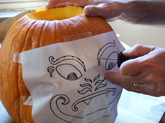 Tape your pattern to the pumpkin and use a punching tool to score the lines of your design onto your pumpkin, punching indentions approximately 1/8 to 1/4 inch apart.