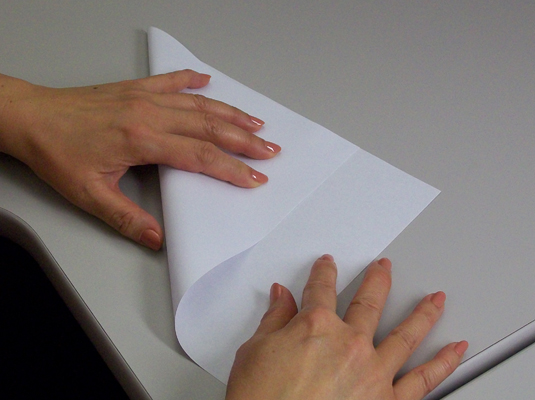 Starting with a standard 8-1/2 x 11-inch sheet of paper, fold two adjacent edges together and make a crease.