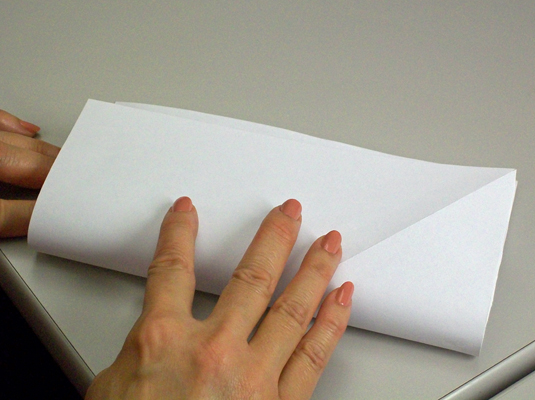 With the paper square in front of you, fold the bottom edge up, align it with the top edge, and crease the bottom.