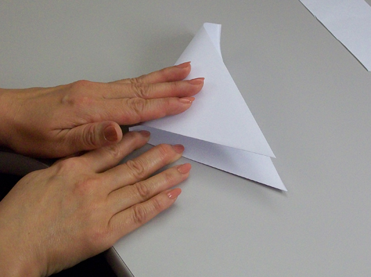 With the folded edge horizontally in front of you, fold the left corner over onto the right corner and crease.