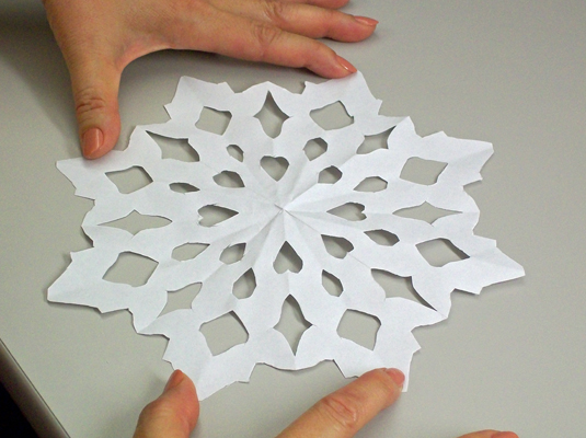 Unfold the snowflake and put it on display.