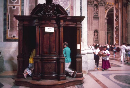 Going to confession may involve kneeling in a confessional and seeing the priest through a screen. 