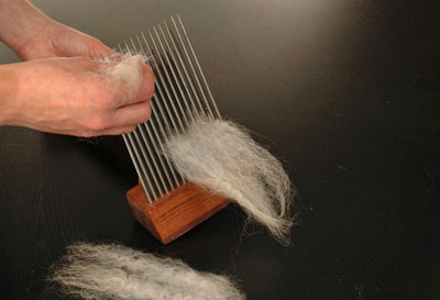 Load the comb that is secured in the box. Take locks of fiber and place them in the comb.