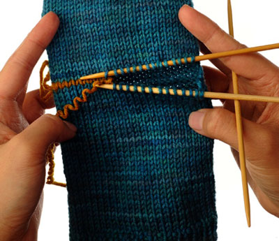 Remove the waste yarn, placing the live stitches onto two double-pointed needles.