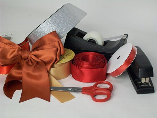 Assemble your materials: spools of double-faced ribbon, sharp scissors, stapler, and tape or a hot glue gun.