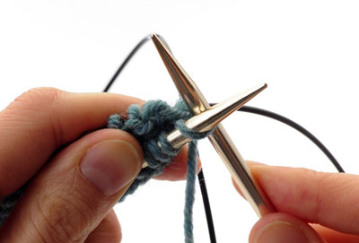 Using the now-empty back needle, knit across the front set of stitches.