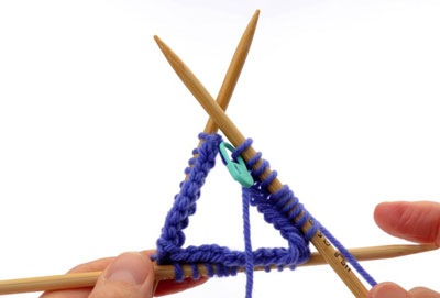When you reach the end of needle 2, rotate your work again and use the empty needle to knit the stitches on needle 3.