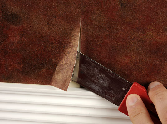 Loosen the wallpaper strip at the corners with a putty knife.