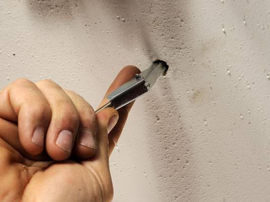 Drill a hole for the mounting toggle bolts in the ceiling.