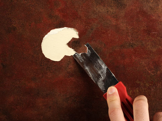 Clean or scrape off stray bits of wallpaper or adhesive in the torn area.