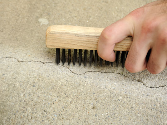 Clean the crack of all debris — dirt, particles of concrete, or pebbles.