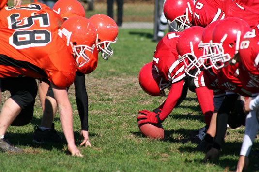 In college and high school, all players on the punting team may cross the line of scrimmage after the snap.