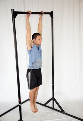 Assume a dead hang position from a pull-up bar or rings. Brace your abs and flatten the arch out of your back — think about trying to mimic the &#147;hollow position&#148; from the V-up.
