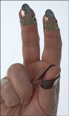 Fitting the fingerpicks on the right-hand index and middle fingers. [Credit: Photograph by Anne Ham