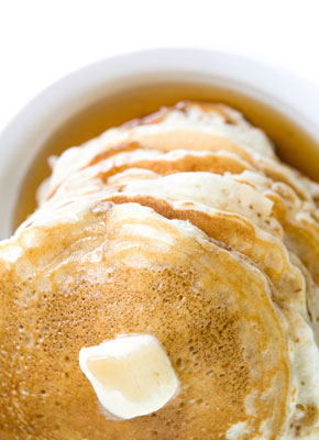 A stack of pancakes with butter on top.