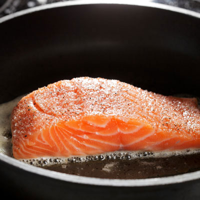 Cooking salmon in a pan.