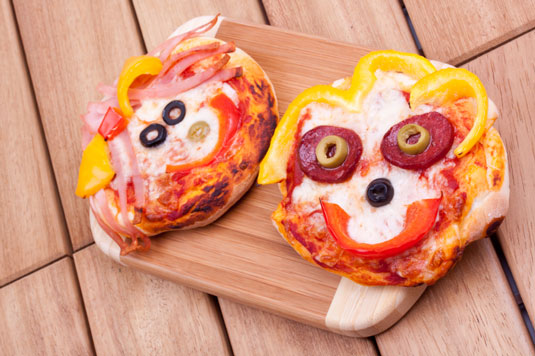 Mini pizzas with smiley faces.