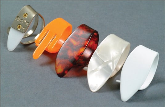 Comparing plastic, metal, and polymer thumbpicks. [Credit: Photograph courtesy of Elderly Instrumen