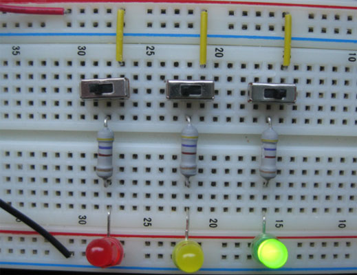 By turning just the rightmost switch on, only the green LED receives current.