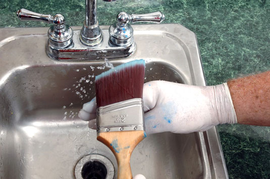 Tap out excess moisture from the brush.