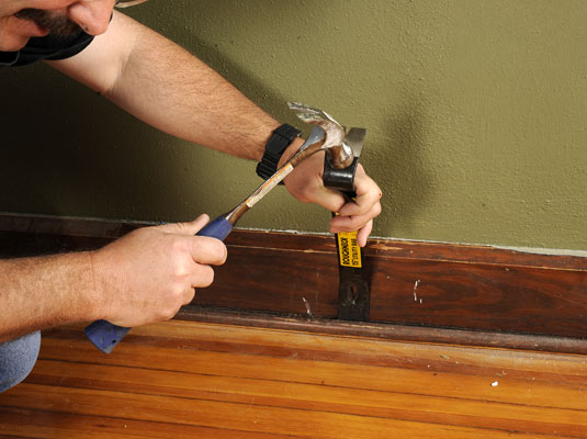 Pull the base shoe moldings away from the wall enough to see the closest nail.
