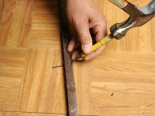 Position the pry bar as close to the nail as possible and use a hammer to help remove base shoe moldings. (Use a nail set to drive a stubborn nail through the molding.)