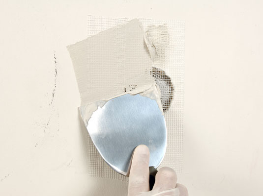 Use a 6-inch taping knife to press the adhesive edges into place.