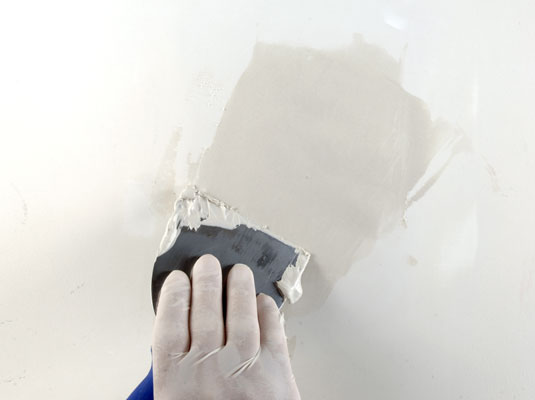 Apply two thin coats of wallboard compound joint compound, letting the compound dry between applications.