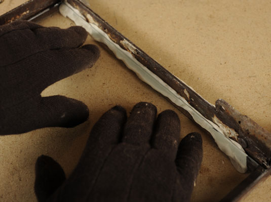 Gently press down the glass at the edges to bed the glass into the putty.