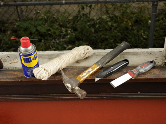 Gather your materials: Lubricant, utility knife, stiff putty knife, hammer, new window cord roping, and screwdriver.