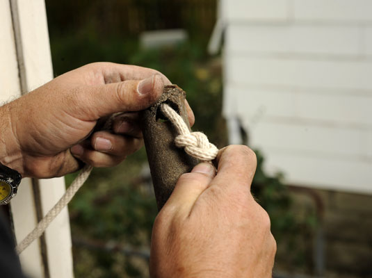 Feed the cords through the hole in the weights and tie a knot.