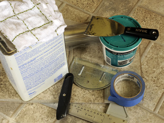 Gather your tools: Patch cut from scrap of vinyl flooring, masking tape, utility knife, putty knife, pencil, floor adhesive, T-square, mineral spirits, rags, rolling pin.
