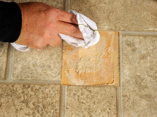 Use mineral spirits to soften the old adhesive on the floor.