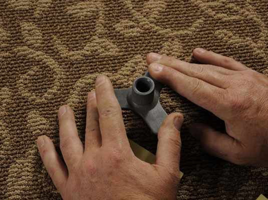 Push an alignment and depth control device into the carpet over an effected floor joist.