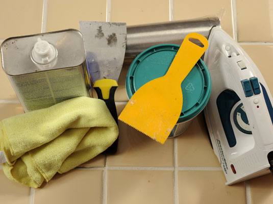 Gather your materials: Iron, tile adhesive, putty knife, mineral spirits, rags, rolling pin.