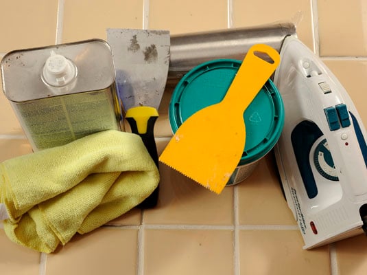 Gather your materials: Iron, tile adhesive, putty knife, mineral spirits, rags, rolling pin.