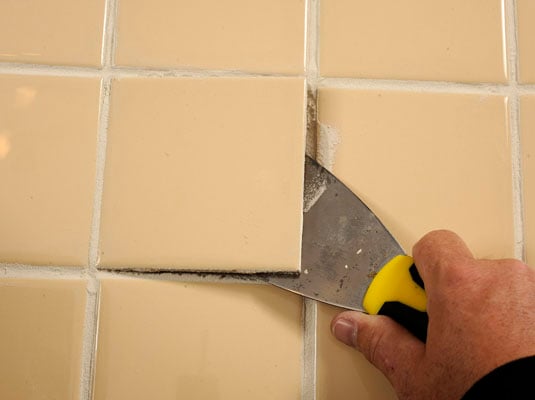 Lift out the loose tile with a putty knife.