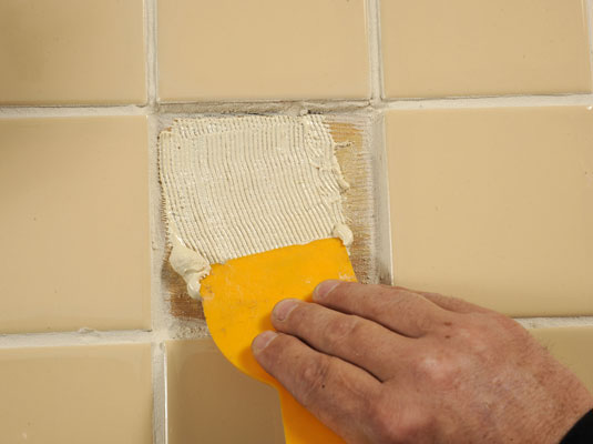 Apply adhesive to the new tile and to the floor.